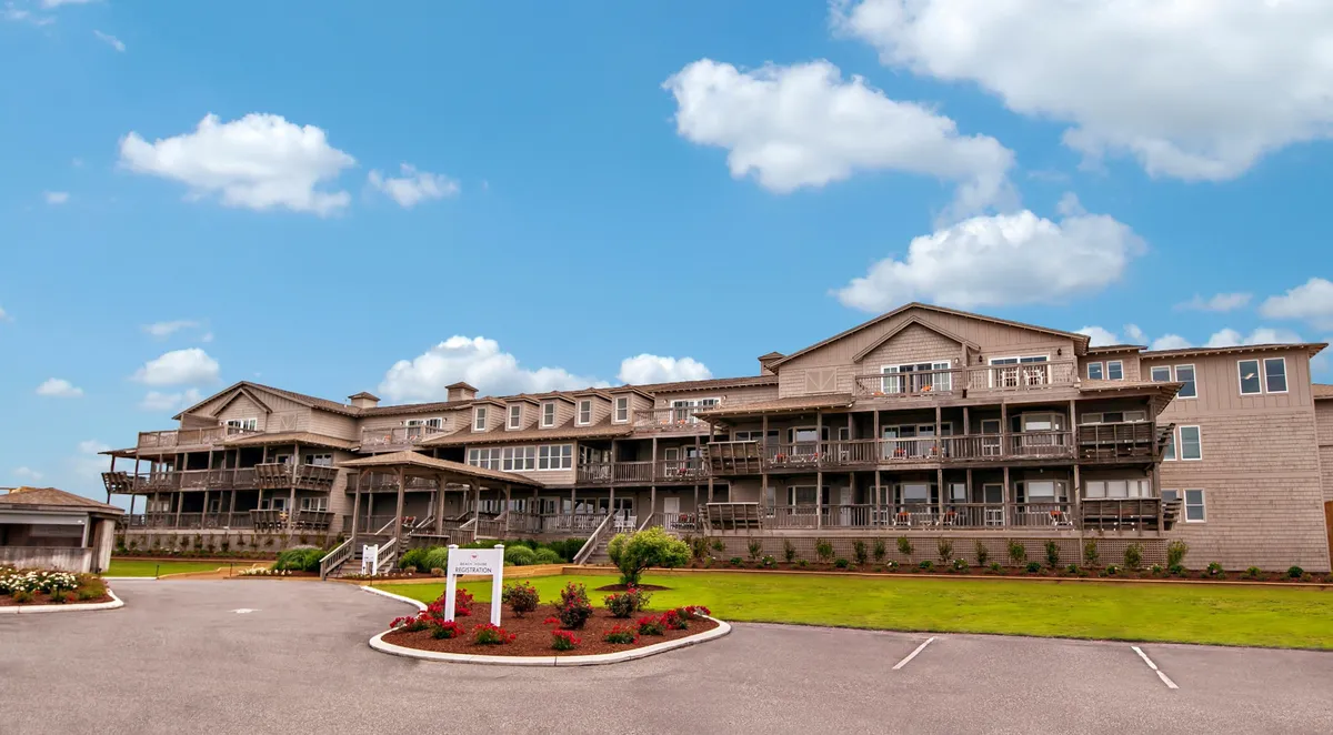 The building’s facade with several private balconies overlooking a lush, landscaped garden. Some balconies feature seating, suggesting a peaceful spot for morning coffee or stargazing. The overall mood is inviting and serene, emphasizing privacy and the connection to nature.